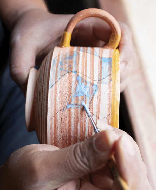 9 Use colored wax to draw a pattern onto the pot, then let dry completely.