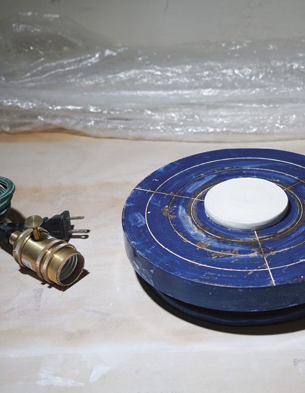 1 On a banding wheel, flatten a clay ball, center and secure it. Trim excess.
