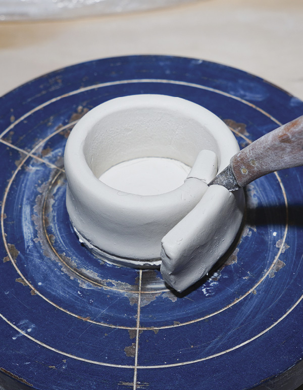 3 Score, add water, and attach a flattened coil to the base. Cut excess.