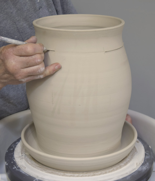 14 Use a needle tool to make a level mark around the circumference of the pot and use a sharp knife, such as an X-Acto blade, to cut three equally spaced slots along this line.
