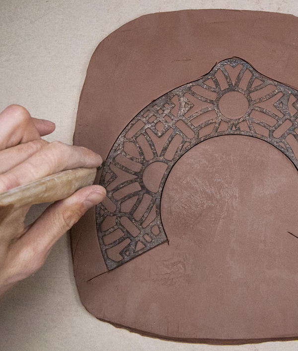 3 Using a sharp knife pointed straight down, slice against the tar-paper edge of the template.