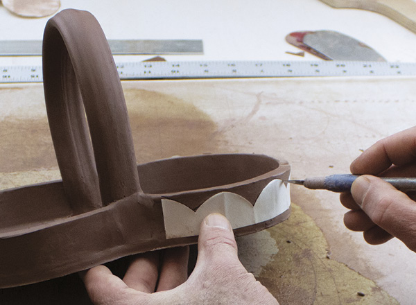 3 Sugar Jaws Pottery applying a template for cutting a scalloped edge on a tray.