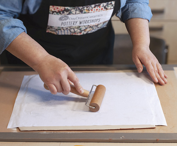 4 With a decisive movement, place the print face down on the slab. Press the print onto the slab with a pony roller and plastic ribs.