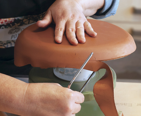 9 When the slab is nicely shaped around the form, use a cheese cutter to remove the excess clay.