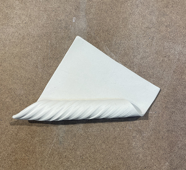 A2 Turn the clay over and tuck in one corner of the square and roll it diagonally until it takes the shape of a crescent roll.