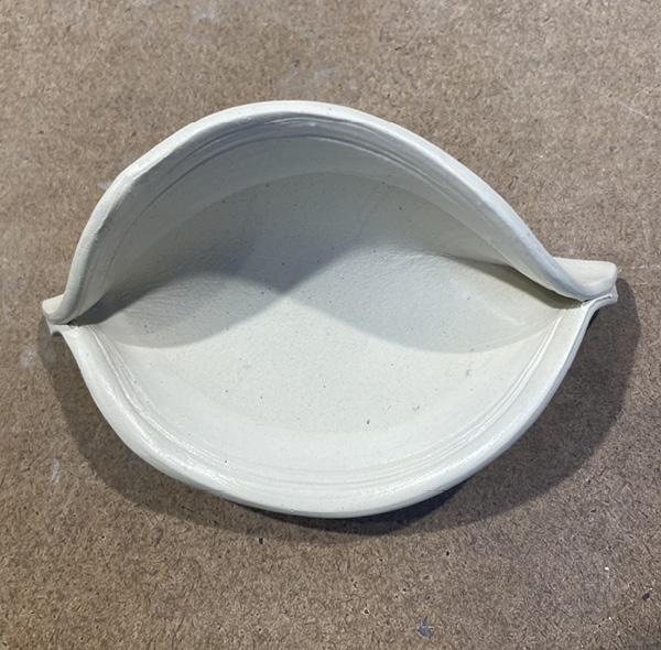 D3 Gently bend and fold over the clay, starting from the tips, into an oval/eye-shaped clay piece.