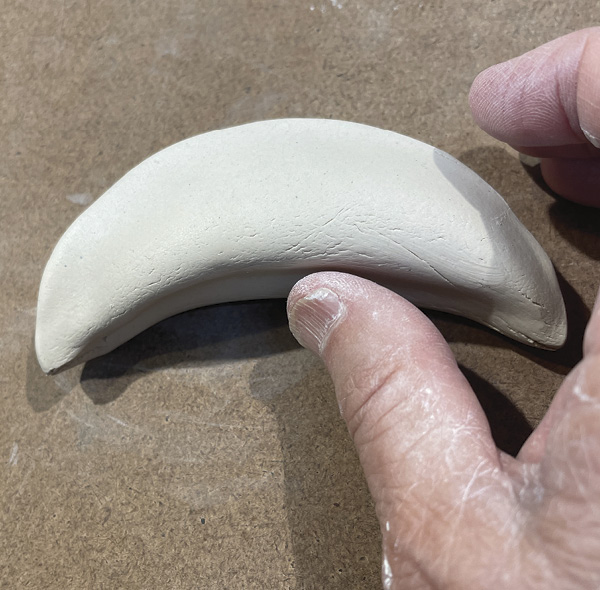 D5 Gently stroke the straight side of the folded clay curving the clay to match the curve of your vessel.
