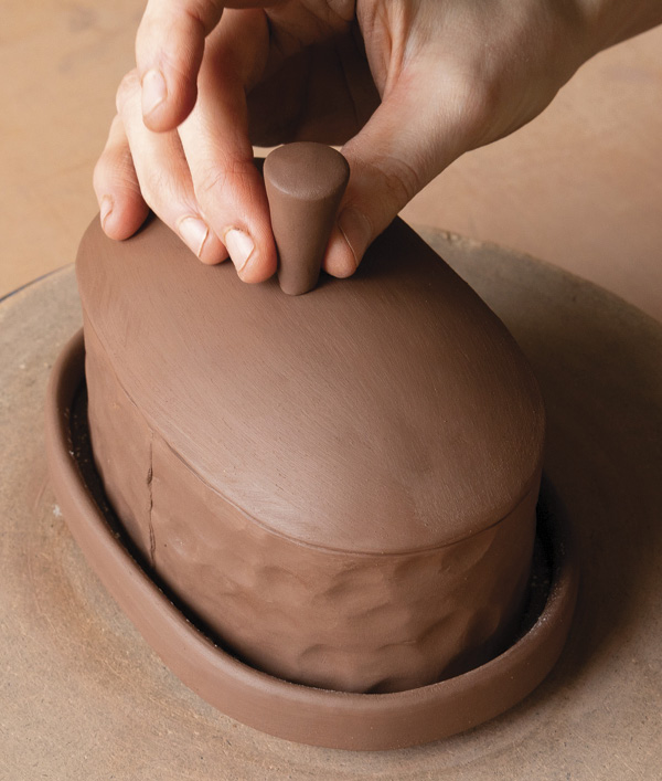 17 Rotate the lid on the banding wheel to find the center for even spacing. Trace the outline, then slip, score, and attach.