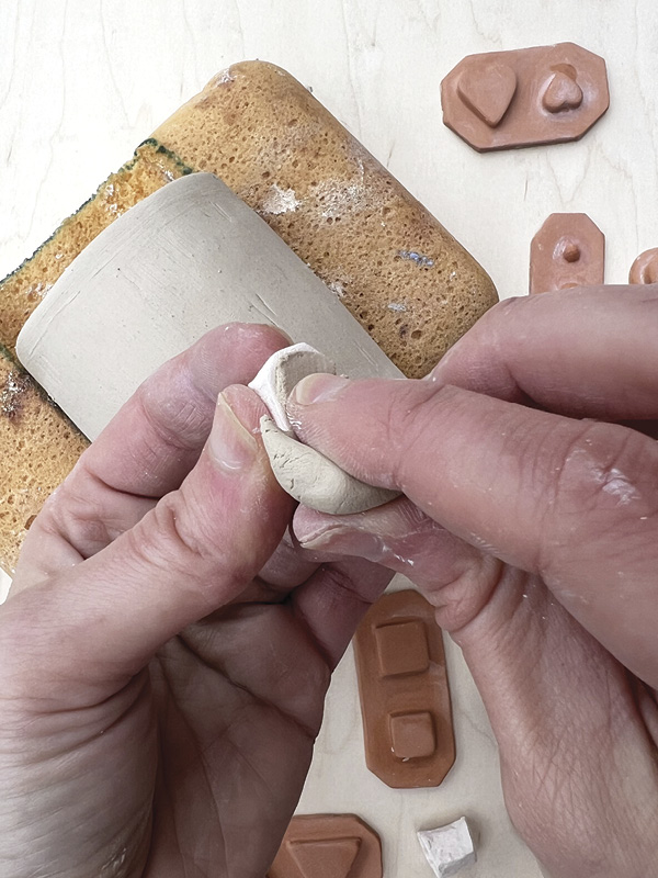 2 Press a small piece of fresh clay into the sprig mold cavity and remove excess.