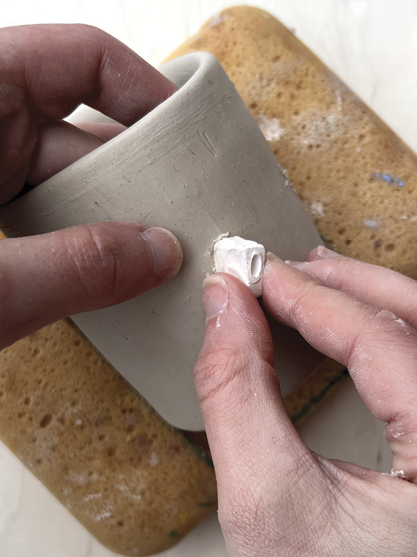 3 Score the clay in the sprig mold. Press the mold firmly onto scored site on pot.
