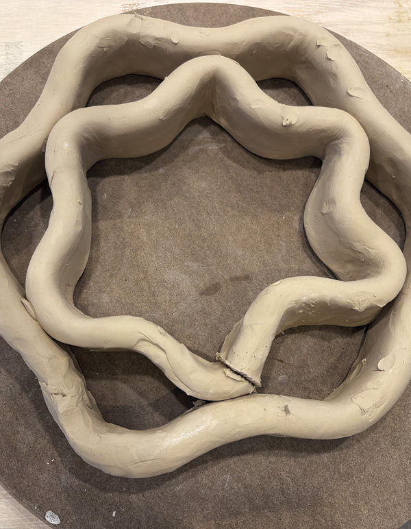 1 Begin by laying out two nesting shapes with coils.