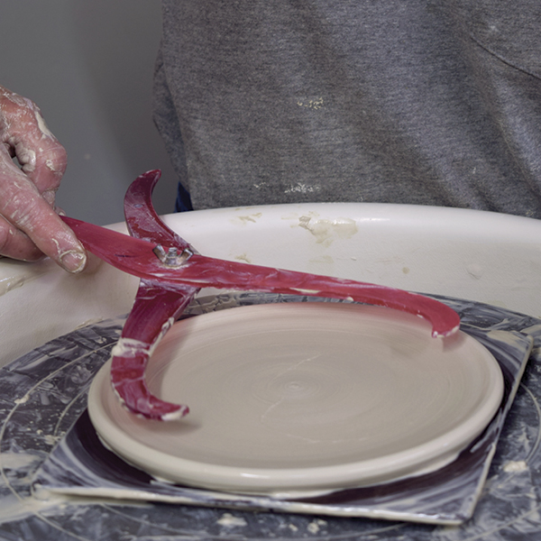 7 Flatten out 1 pound of clay to make a saucer wider than the base of the bowl.
