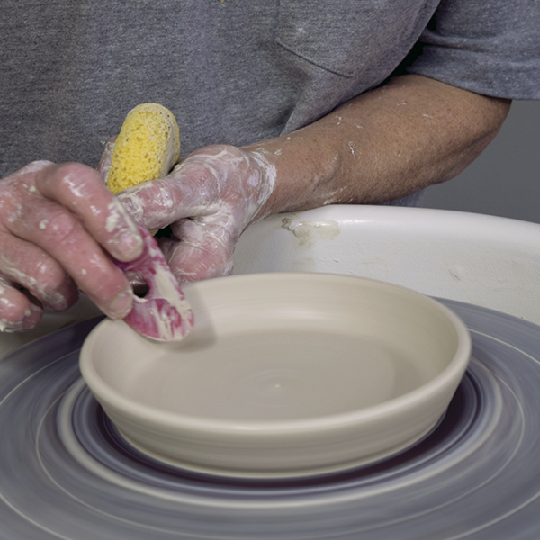 8 Lift the edge of the saucer, then use a soft rib to flare its rim.