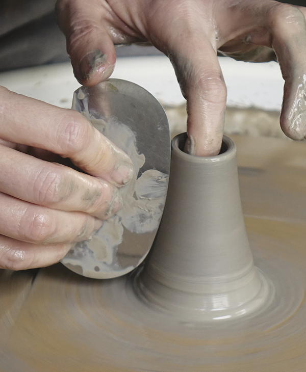 5 Throw the spout by forming a narrow cylinder. Remove the excess slip and smooth the rim.