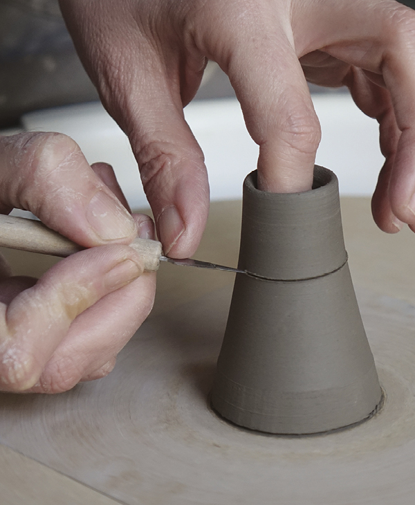 6 Center the firm, narrow form on the wheel and score through the clay until the spout cleanly detaches.