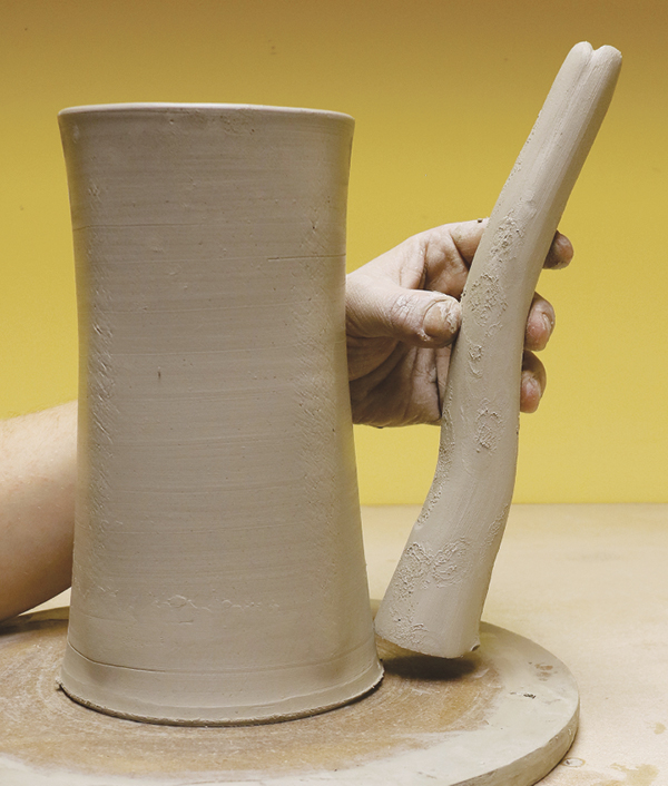 4 Pull a long spout, then hold it up to the body of the pot and shape it into a gentle S-curve.