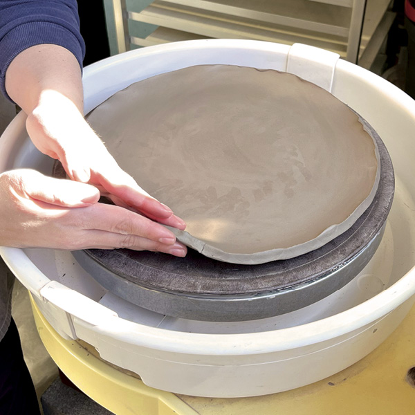 4 Begin to lift the walls with wet hands while the wheel is at a low speed.