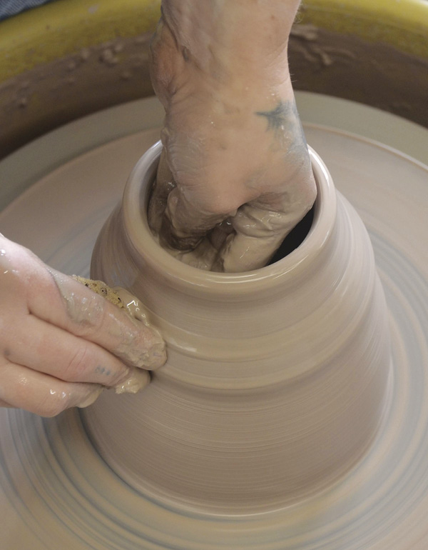 2 Pull the walls up and in. Round the belly and keep the rim thicker and centered.