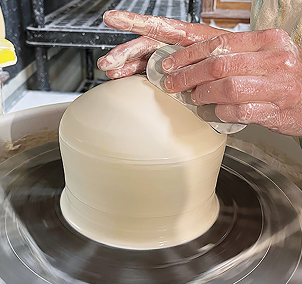 5 With air trapped inside, use a rib to can clean off the slip then refine the shape.