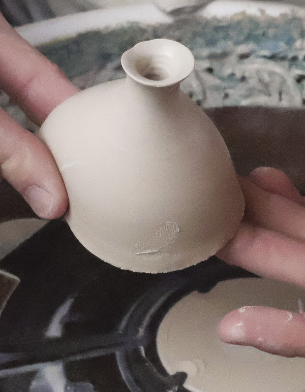 6 Cut off the spout. Pinch the opposite side off the wheel to create a swell.