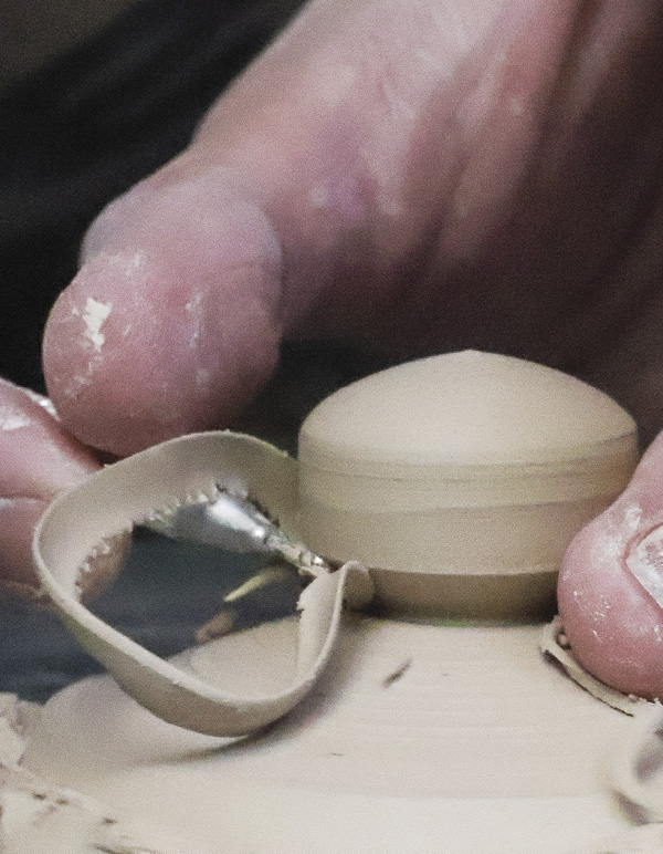7 Secure the lid upside down on the wheel and trim the pedestal into a finial.