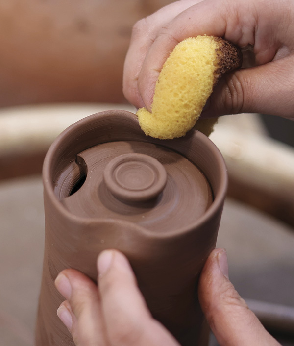 12 With the lid inside the cylinder, use a damp sponge to carefully crimp the rim inward on either side.