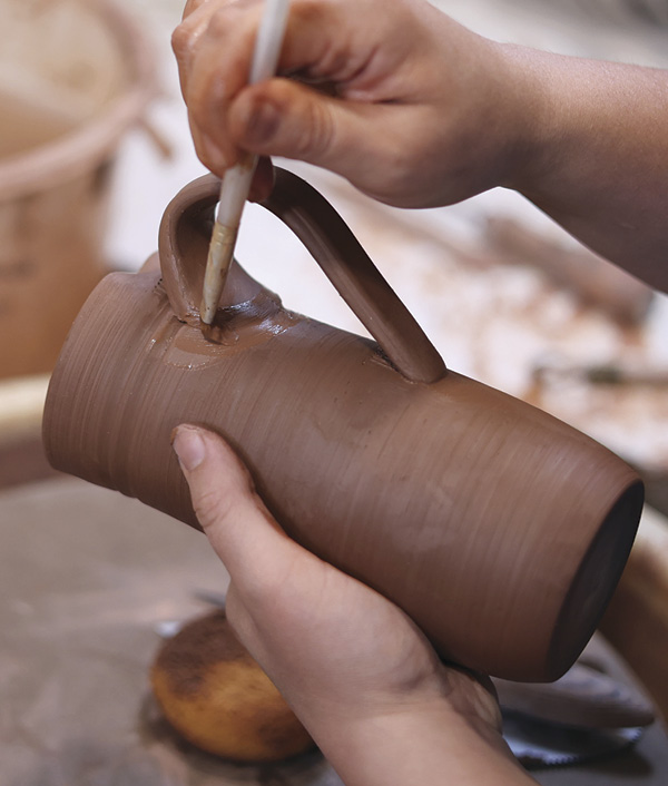 15 Score, slip, and attach the handle, ensuring the lower attachment is roughly 3 inches up from the bottom.