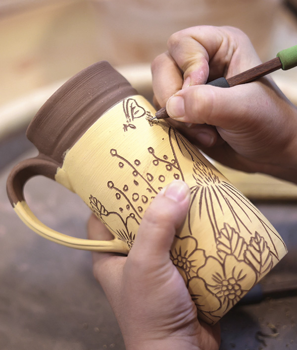 18 Next, carve a nature-inspired sgraffito design through several coats of dry yellow underglaze.