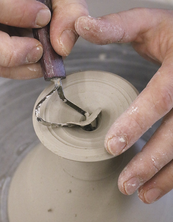 13 Remove excess clay from between the line and the hole in the center of foot.