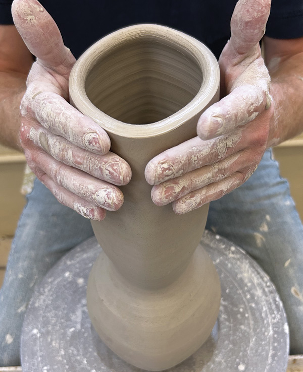 3 Using your full hands, press the vessel into an oval shape.
