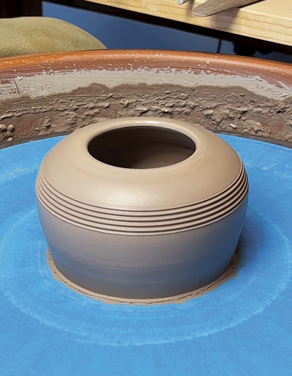 4 Throw a short rounded base form with a medium wide opening. Add grooves.