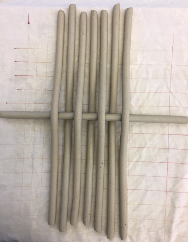 1 Lay the coils parallel and start the first weave horizontally, in the middle.