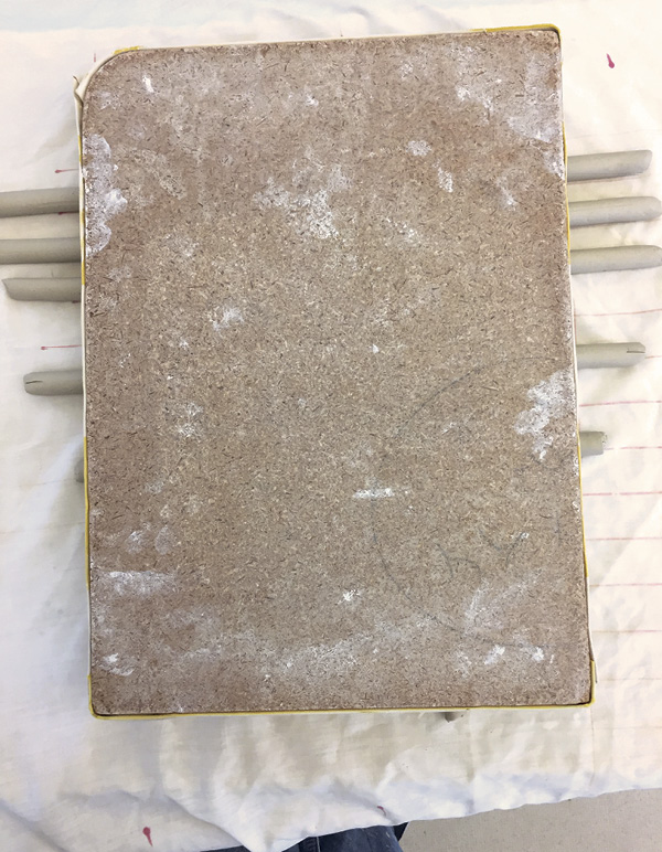5 Place a cloth-covered ware board on top of the weave, and evenly compress.