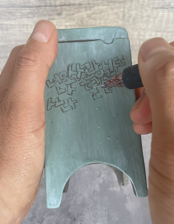 10 When the surface is dried, carve the design through the wax.