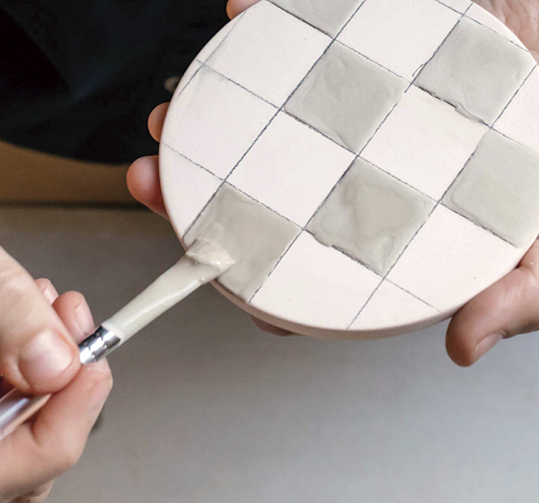 4 Fill the sketched designs with glaze using a brush.