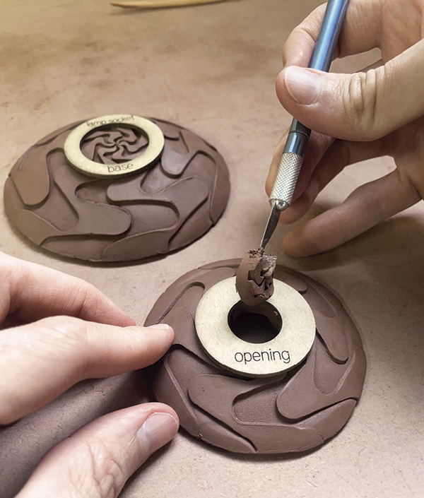 8 Cut holes in the top and bottom pieces that were just formed.