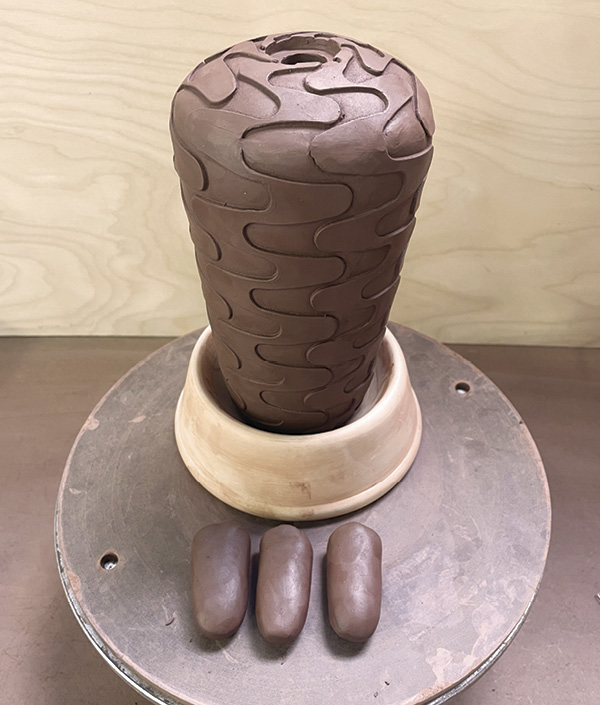 14 Shape three lugs of clay into the desired foot shape.
