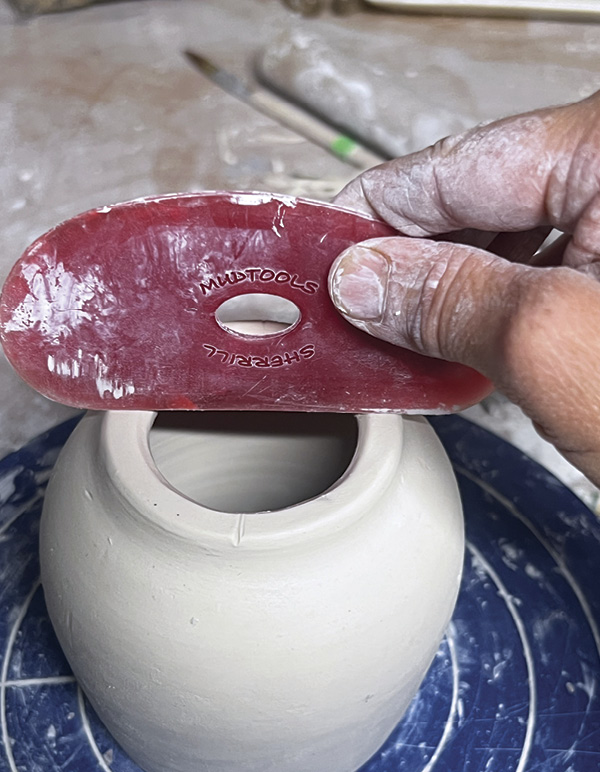 2 Divide base into four sections by making shallow marks in the clay.