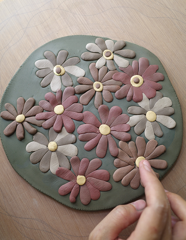 5 Place petal shapes of different colors and press them gently with a finger.