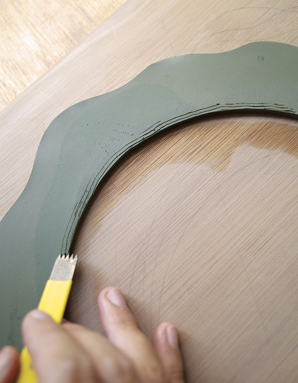 10 Smooth the edges, then score the back where the mirror will later be attached.