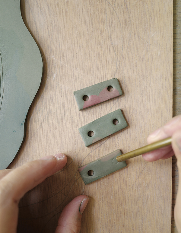 11 Use leftover clay to make three rectangular tabs and pierce two holes in each.