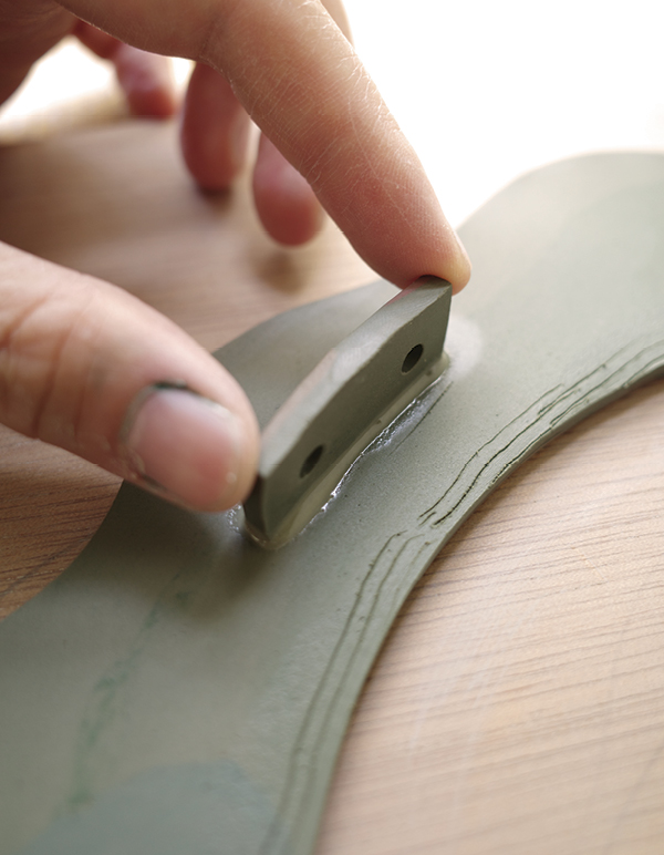 12 Attach the tabs at evenly spaced intervals to the back of the frame.