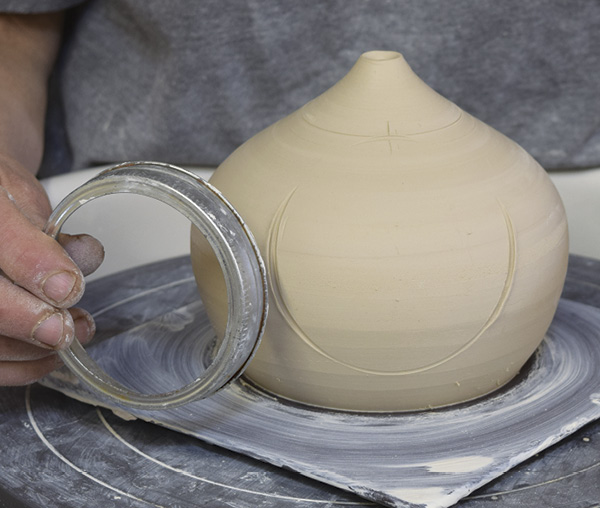 5 Make a mark by pressing a large mason jar rim or other circular object into the surface of the clay with the top edge on the line you drew. Repeat on the other side.
