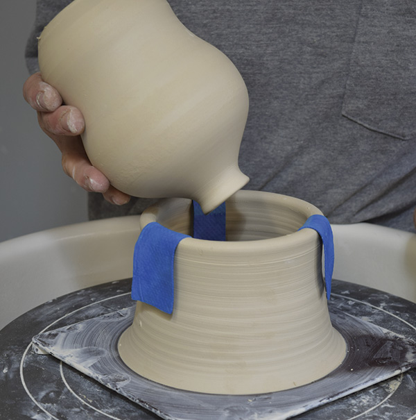 4 Make a trimming chuck by using about a pound of clay to throw a short, sturdy cylinder with a thick rim. Make the rim match the caliper measurement. Once the feeder and chuck are leather hard, put the bat with the chuck back on the wheel.