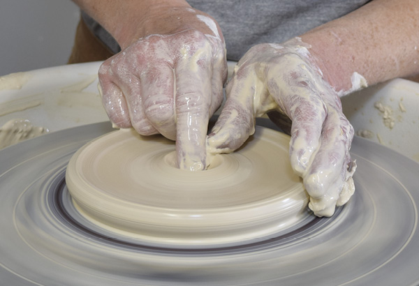 6 Using 1½ lbs (0.7 kg) of clay, create the lid. Flatten the clay out into a thick pancake, then open up in the center of the pancake, leaving the floor ¼ in. (0.6 cm) thick.
