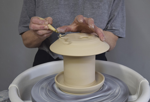 10 When both pieces are leather hard, place the roof on the feeder and trim to a smooth curve.