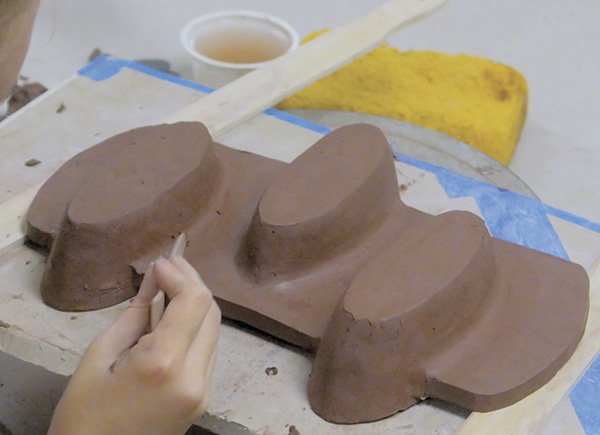 6 Add a coil to the outside seams for strength, then compress and blend the coil with a rounded wooden knife.