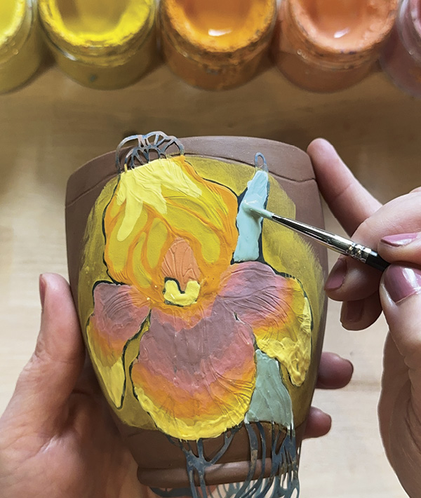 3 Add 2–3 layers of underglaze over the stencil, using a spectrum of colors to build depth and interest to the design.