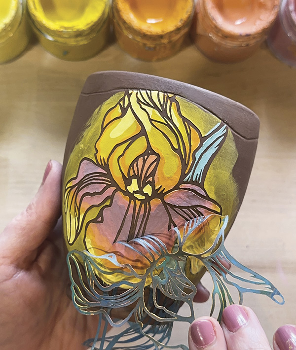 4 Carefully lift and slowly remove the stencil once the wet sheen from the underglaze dissipates.