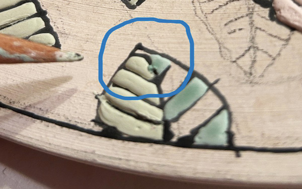 7 If glaze flows over a wax line (top), use a pencil tip to scrape it off (bottom).
